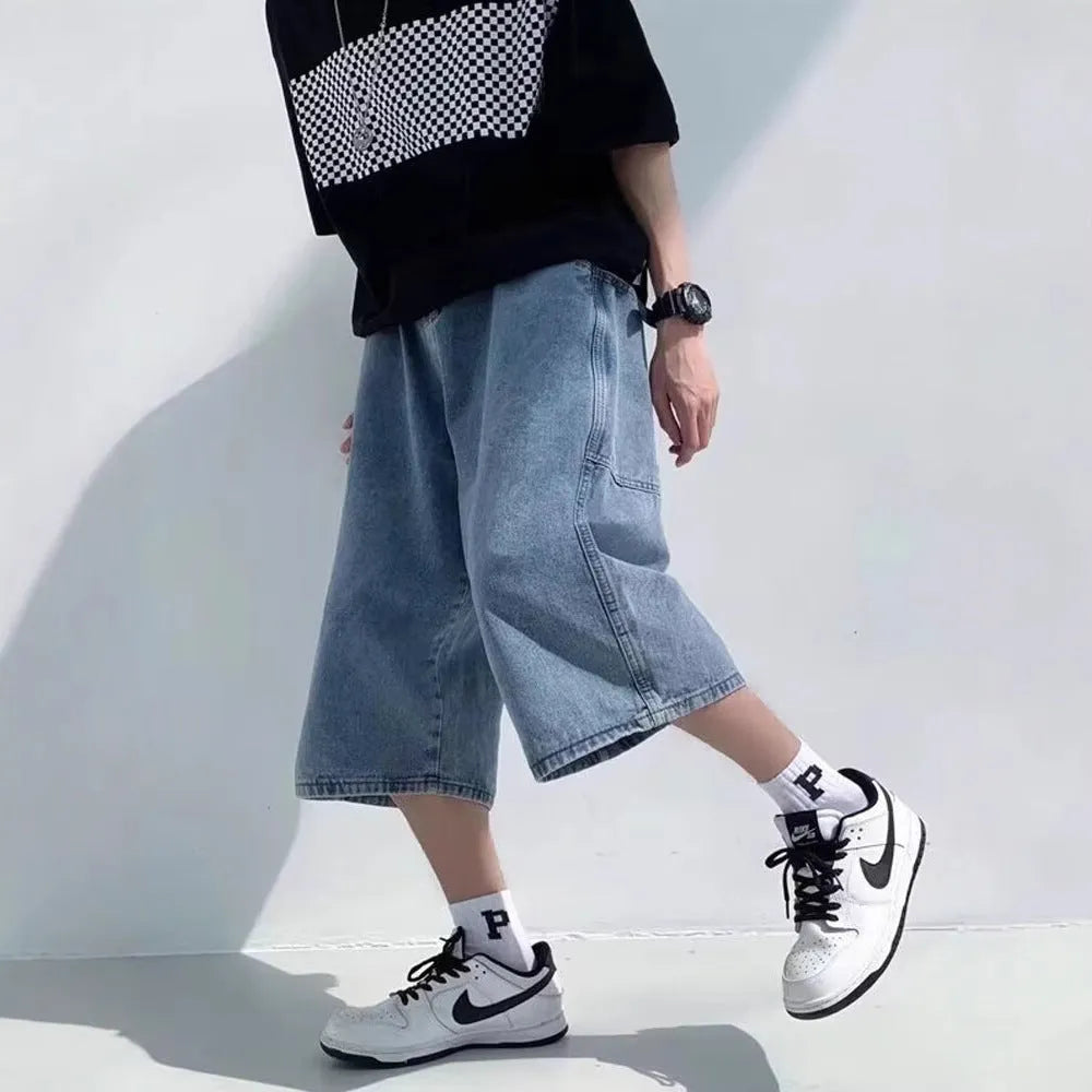 Blue men's cropped high-waisted denim-style shorts with a zipper fly on a white background.