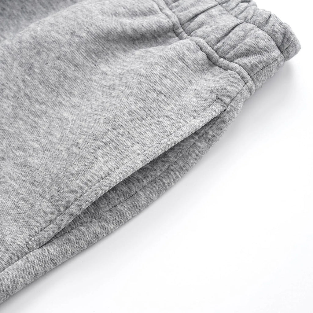 Men's solid colour cotton straight leg trousers with a loose wide-leg casual fit on a hanger.