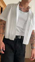 Man wearing a white cropped length short sleeve polyester shirt, casual style.