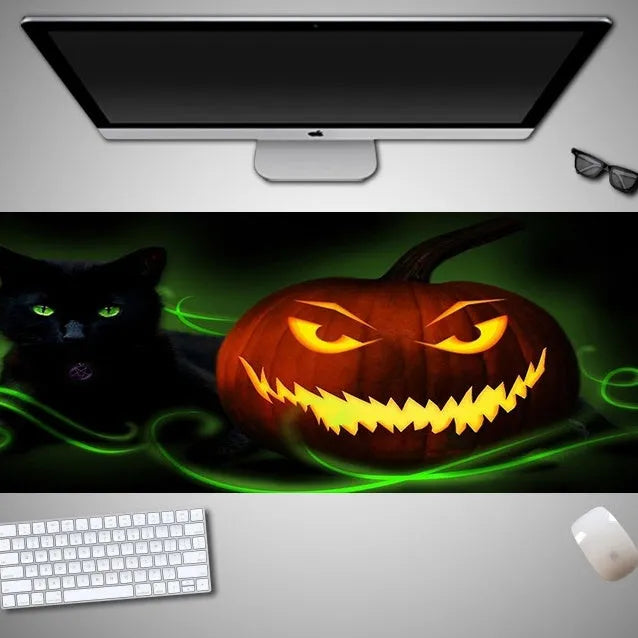 Oversized Halloween-themed gaming mouse pad on a desk, showing anti-slip base and graphic design.