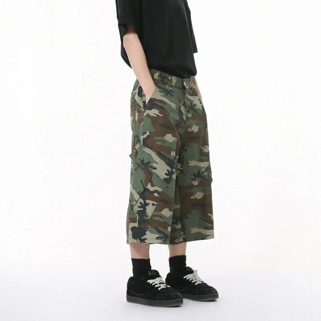 Men's cropped length camouflage cotton wide-leg jeans with large side pockets on a plain background.