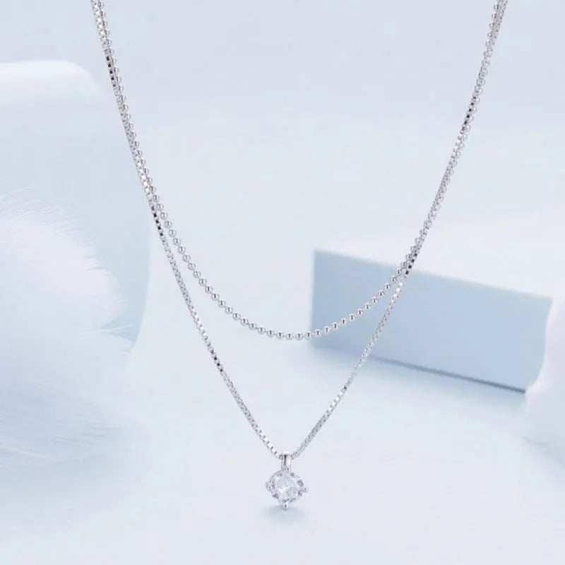 Close-up of a women's double-layer pearl chain sterling silver necklace with a matching pendant.