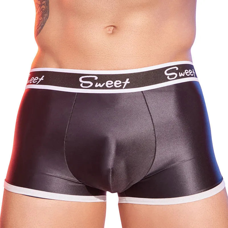 Man's shiny silky nylon boxer briefs in black, white, and sapphire blue colours laid flat.