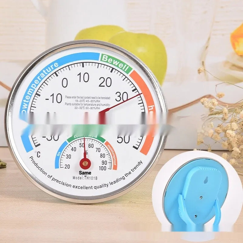 Indoor wall thermometer with plastic black shell and black plastic pointer on a wall