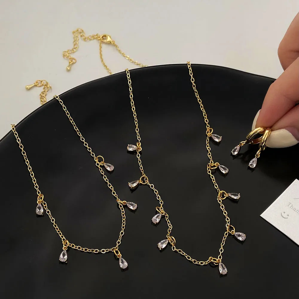 Zircon three-piece jewellery set with geometric meteor shower pendant necklace, matching earrings, and anklet.