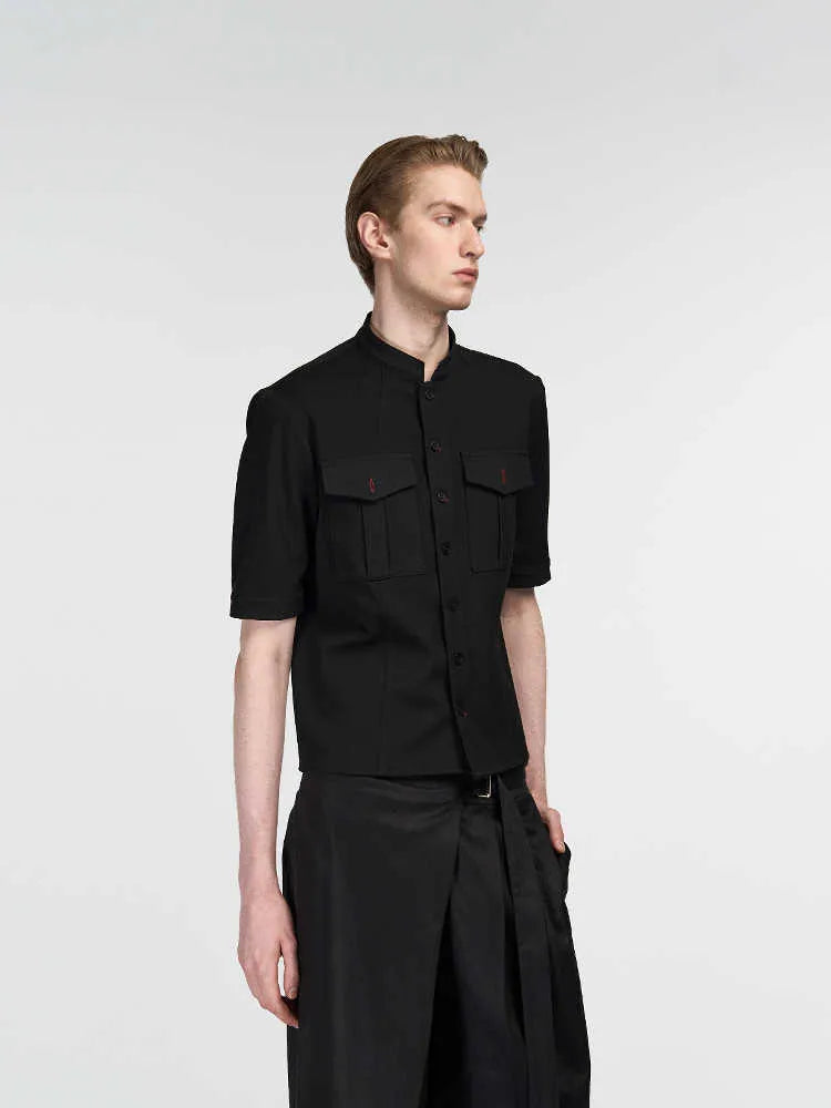 A black handmade half sleeve shirt with a shirt collar, shown on a hanger.