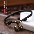 Adjustable nylon dog collar with a brass bell on a black rope, showing the fitting and casual style.