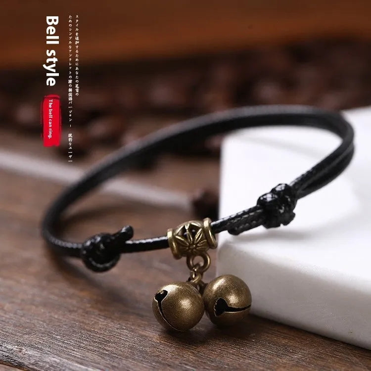 Adjustable nylon dog collar with a brass bell on a black rope, showing the fitting and casual style.