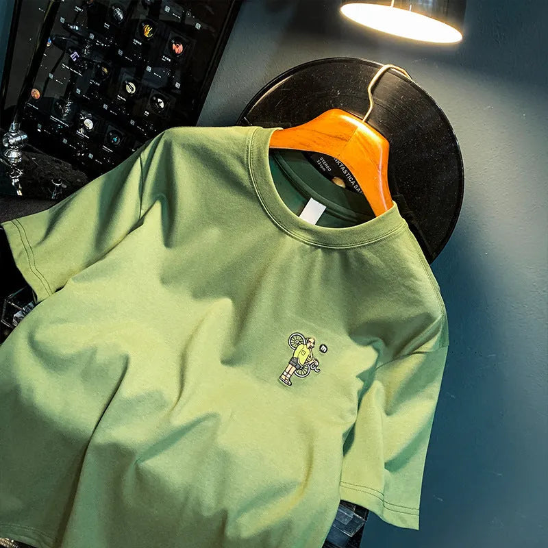 Men's green loose-fit short sleeve t-shirt with printed design on fabric, laid flat to show size.