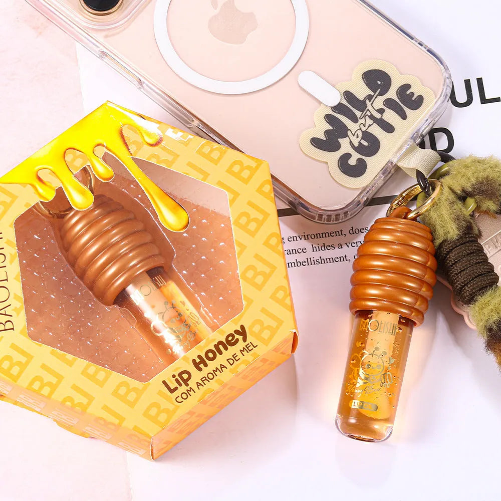 Honey lip gloss on a silver keychain clip against a neutral background.