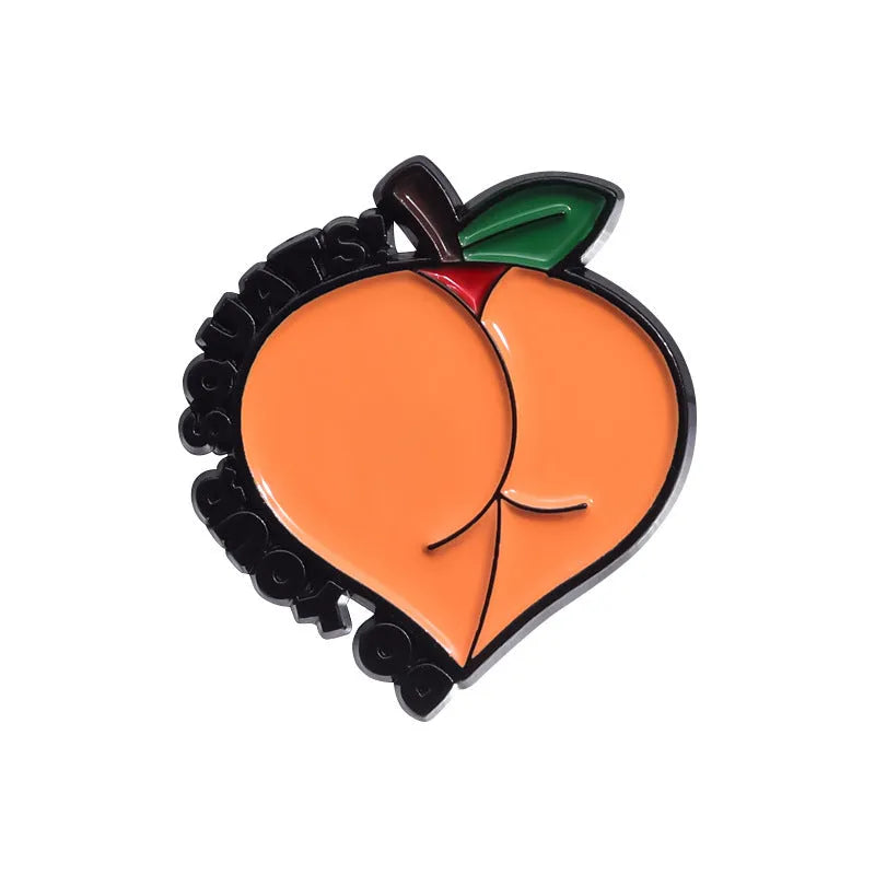 Colourful cartoon fruit design metal letter brooch on a fabric background.