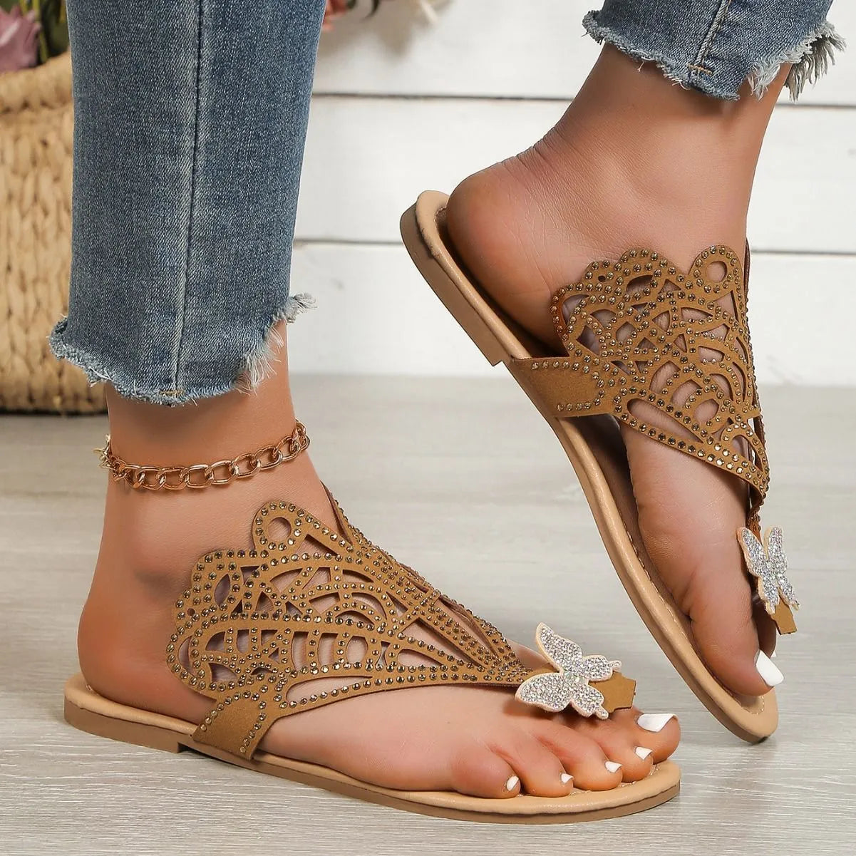 Women's black slip-on sandals with flip-toe design, rhinestone decoration, hollow-out detailing, and a flat rubber sole.