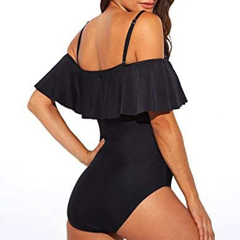 Black one-piece swimsuit with cut-out design and ruffled straps laid flat.