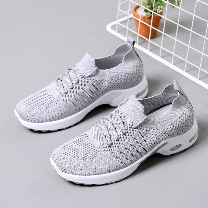 Women's black mesh casual sneakers with round toe and lace-up front on a grey background.