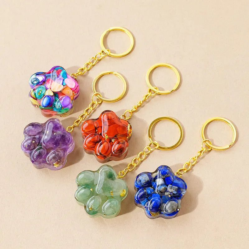 Small crystal cat's paw keychain pendant on a keyring, shown in various gemstone colour options.
