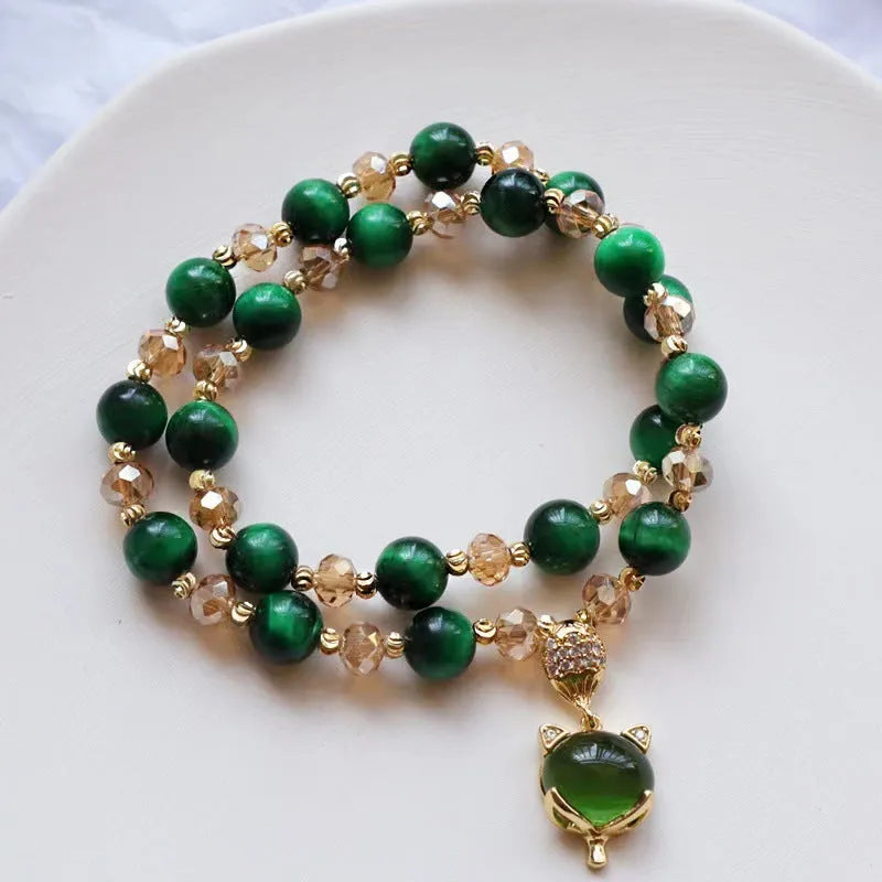 Handmade Tigereye stone bracelet with animal charm clasp on wrist, showing single and double chain styles in green and rose red.