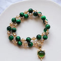Handmade Tigereye stone bracelet with animal charm clasp on wrist, showing single and double chain styles in green and rose red.