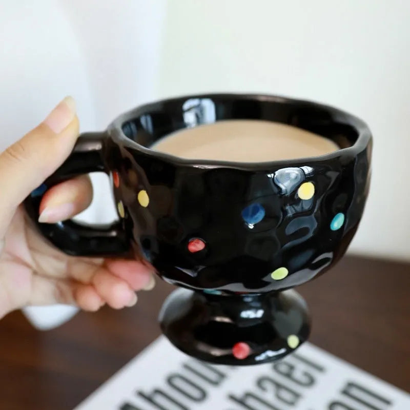 Handmade irregularly shaped ceramic mug in a solid colour, shown on a table.