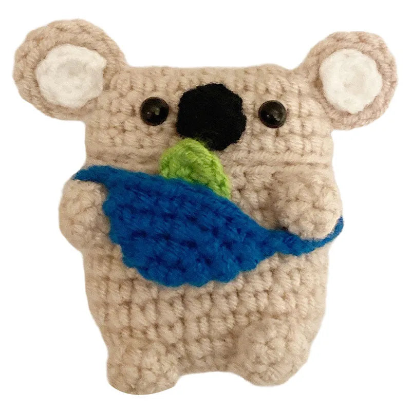Hand-knitted grey koala bear backpack case for Apple AirPods on a wooden table.