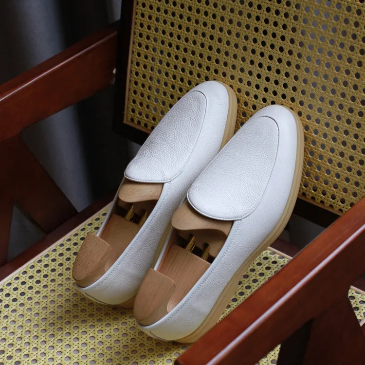 Men's brown genuine leather slip-on loafers on a white background.