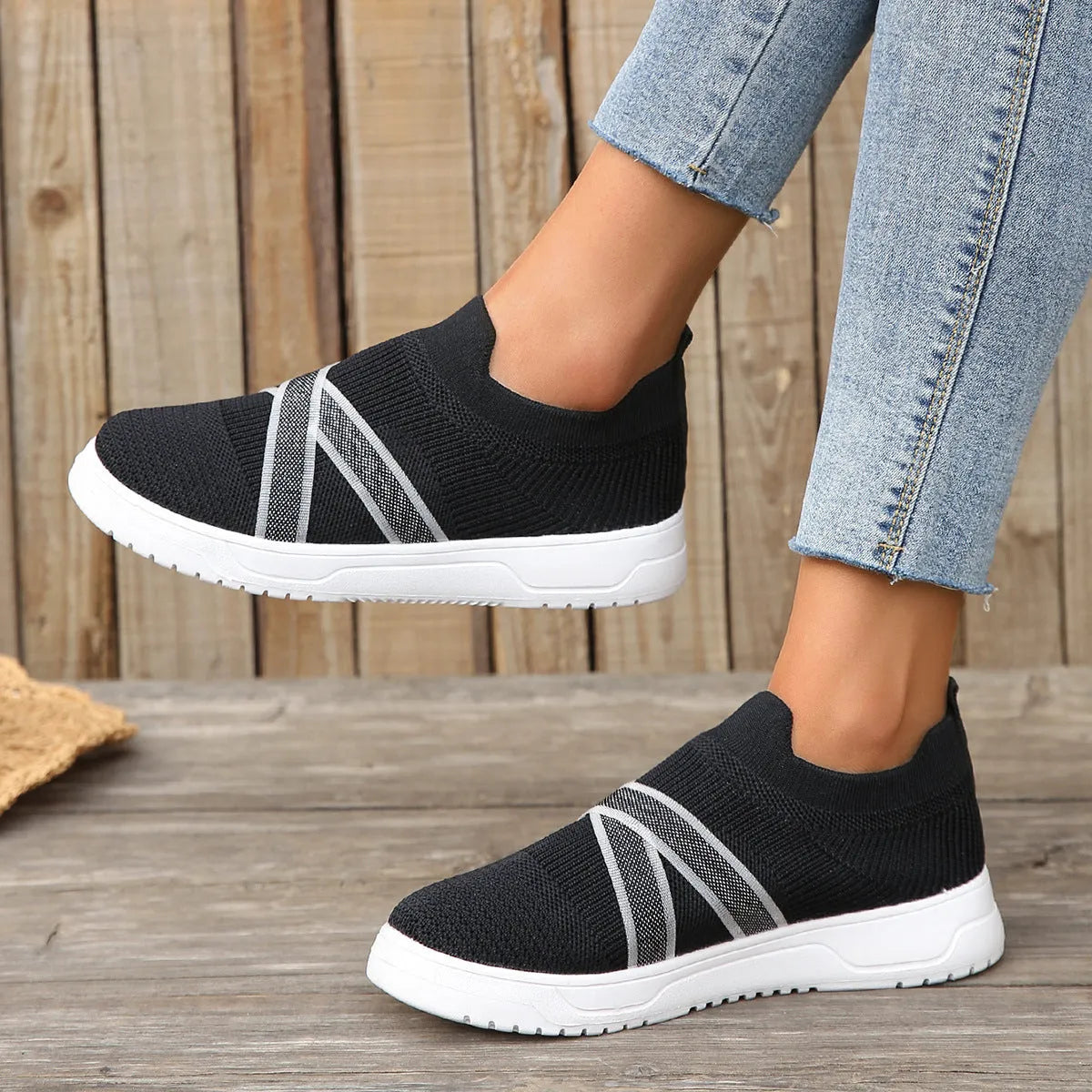 Black women's low-top casual shoes with Flyknit mesh fabric and a flat rubber sole.