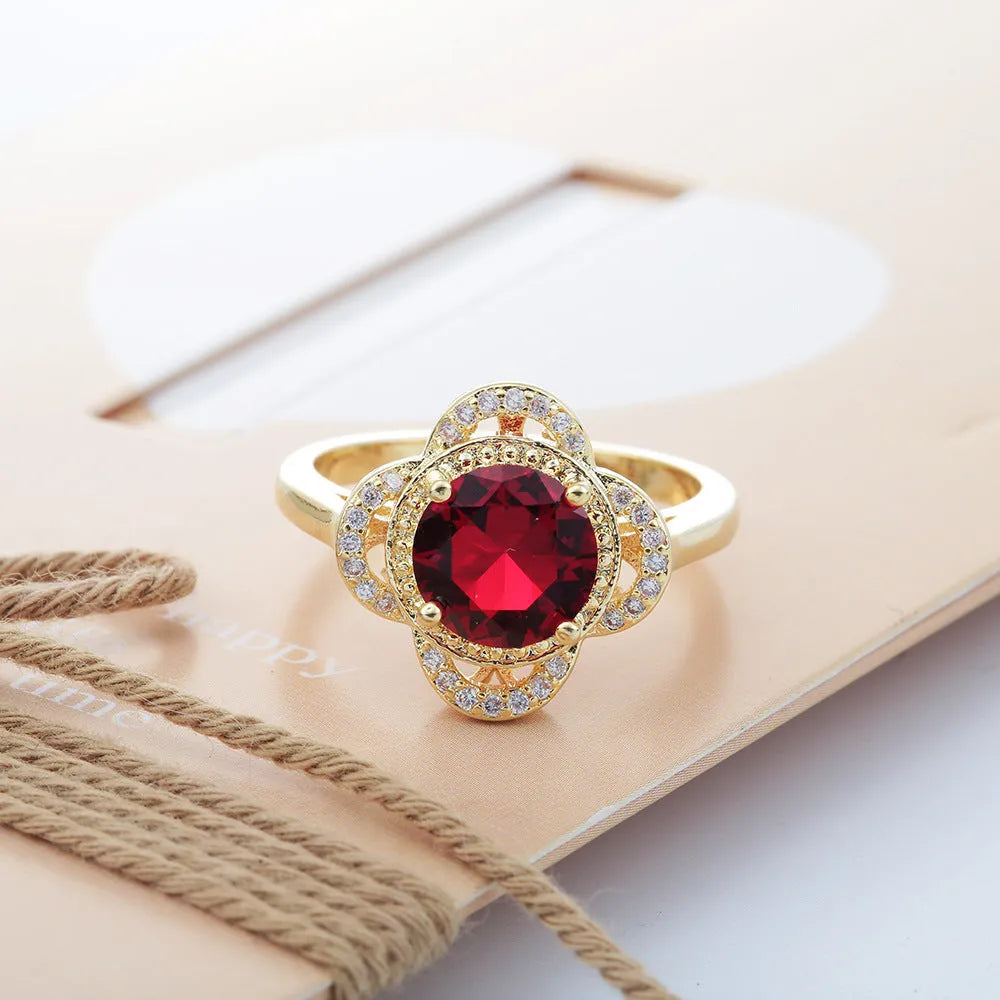 Copper ring with a fruit shape design and zircon stone inlays on a hand.