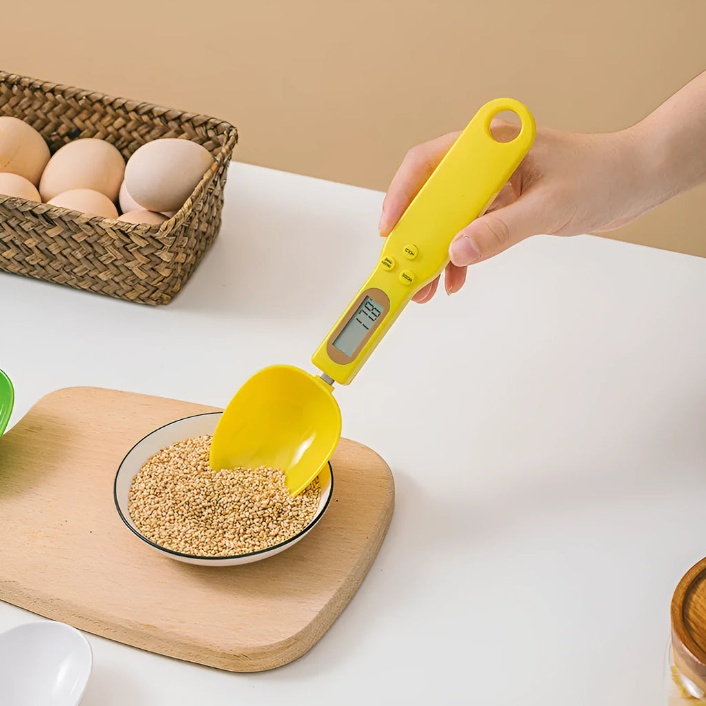 White digital spoon scale with LCD display measuring 500g capacity on a kitchen surface