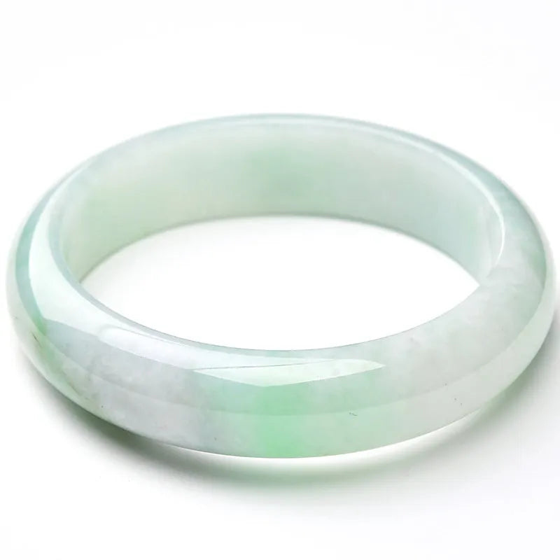 Light green jade bracelet on wrist, natural style, showing sizing scale from 53mm to 64mm