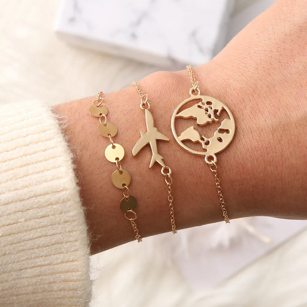 Three bohemian-style bracelets with aircraft map heart charms in electroplated alloy