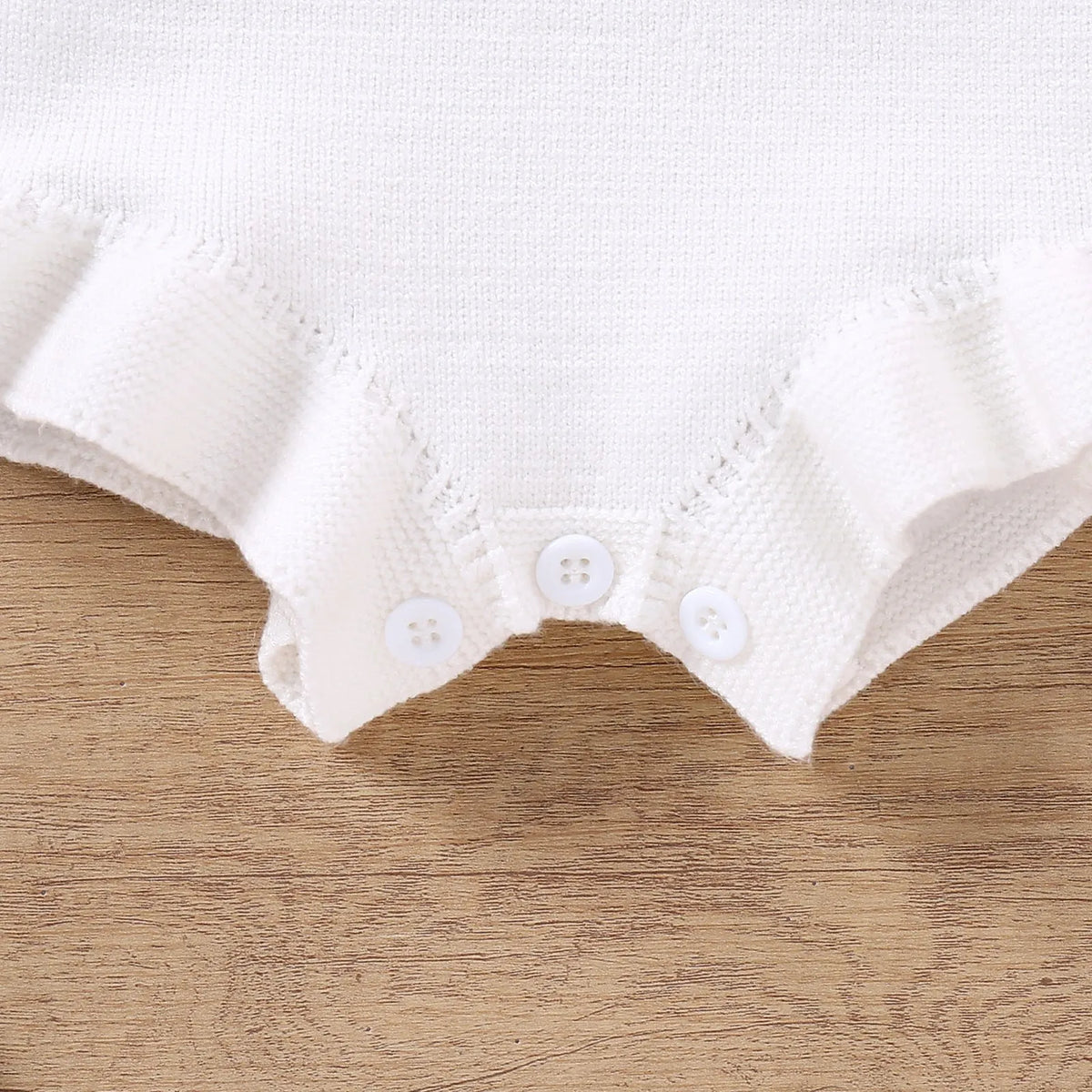 Baby sling-style wool blend romper with bow embroidery, in white or pink, sizes 0-3M to 12-18M