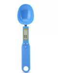 White digital spoon scale with LCD display measuring 500g capacity on a kitchen surface