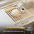Foldable milky white stainless steel kitchen draining rack shown open and folded, next to a sink.
