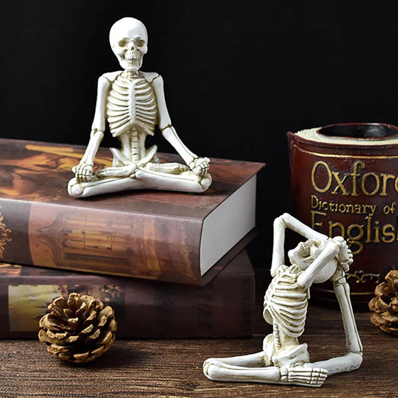 A detailed resin desktop ornament of a yoga-pose skeleton skull in black and white colour options.