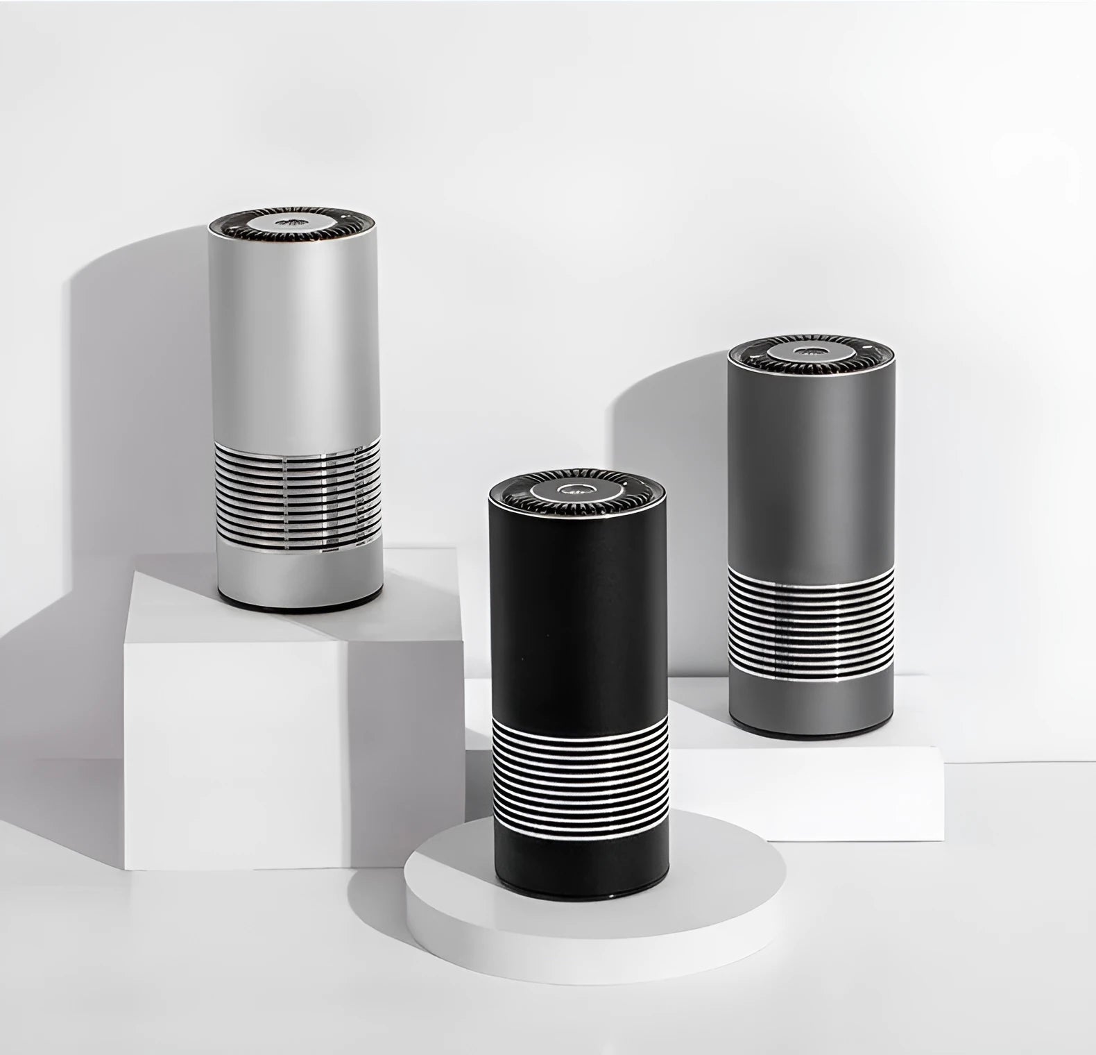 Wireless car air purifier in black, metallic grey, or silver colours, showing compact size for dashboard use.