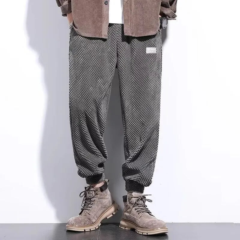 Men's grey straight leg sweatpants with ankle strap detail on a plain background.