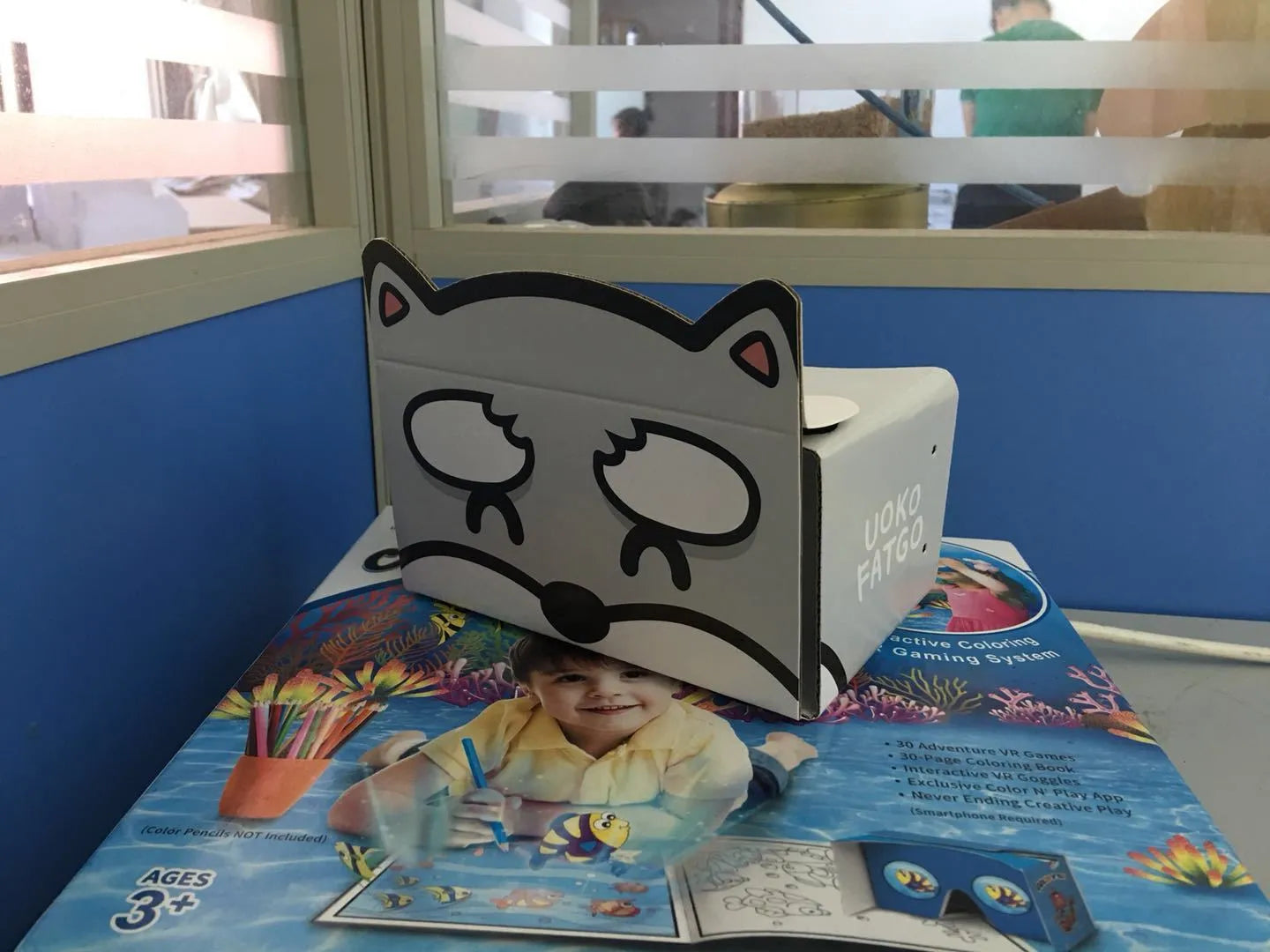 Pink and white VR Cardboard Glasses headset for 6-inch smartphones on a table.