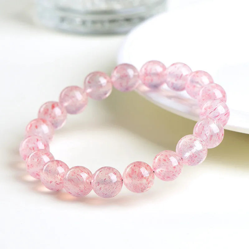 Natural white water strawberry quartz bracelet with 10-10.8mm geometric beads on a wrist.