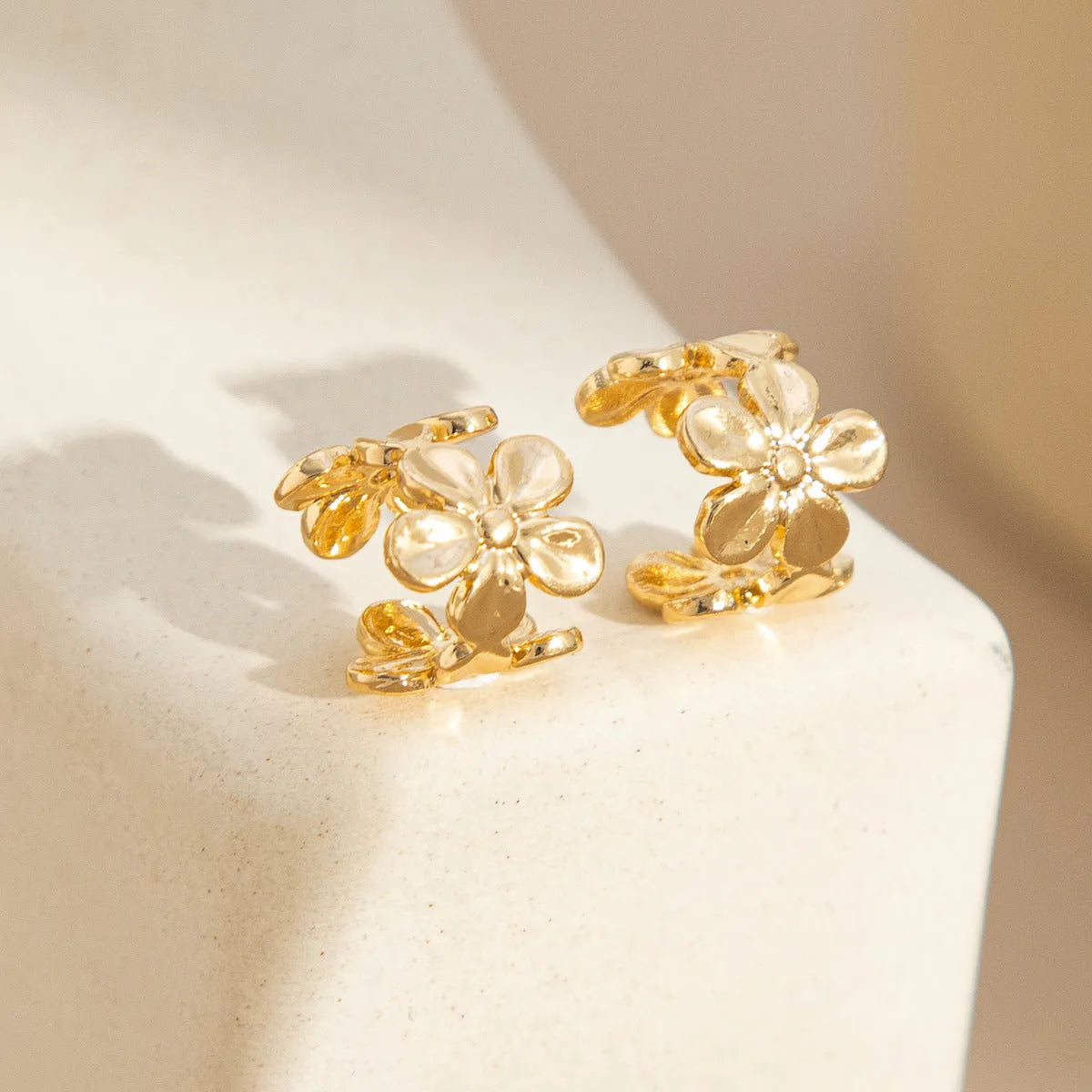 Gold-coloured alloy earrings with starfish and scallop shell designs.