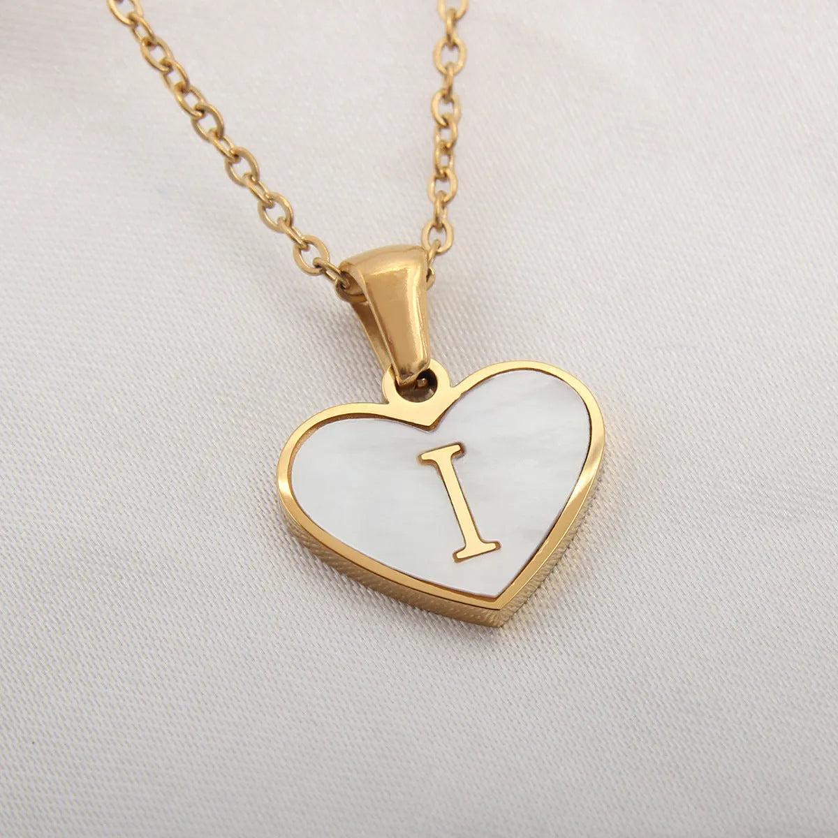 Gold plated chain necklace with a white shell heart-shaped pendant personalised with a single letter initial.