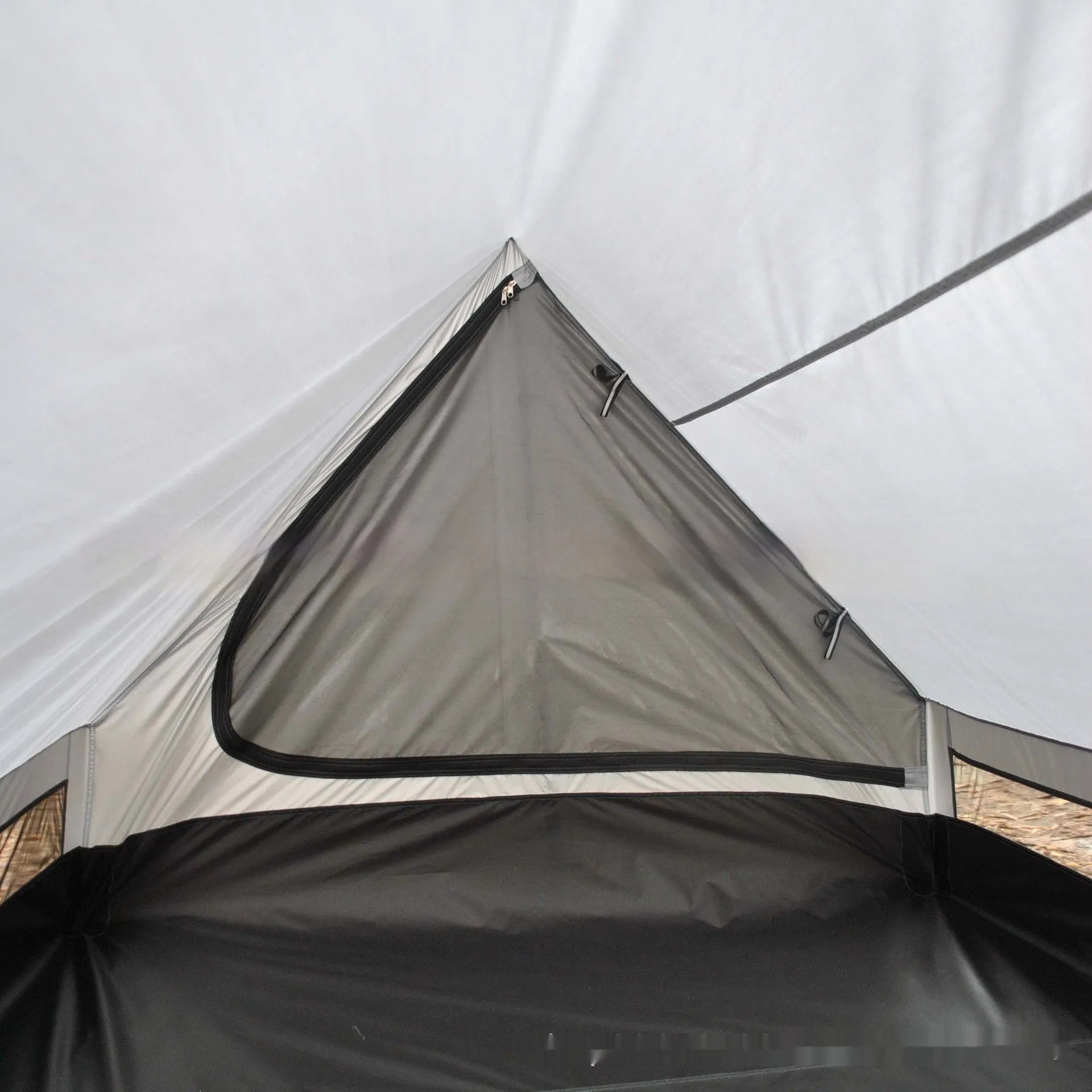 Brown A-line tent pitched with hiking poles, showing guy lines and aluminium ground nails.