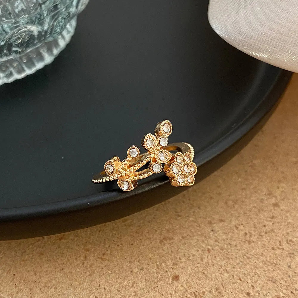 Open mouth floral ring with diamond-treated surface showing flower and leaf pattern in copper