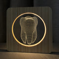 Tooth-shaped wooden-colour acrylic night lamp with USB cable on a surface.