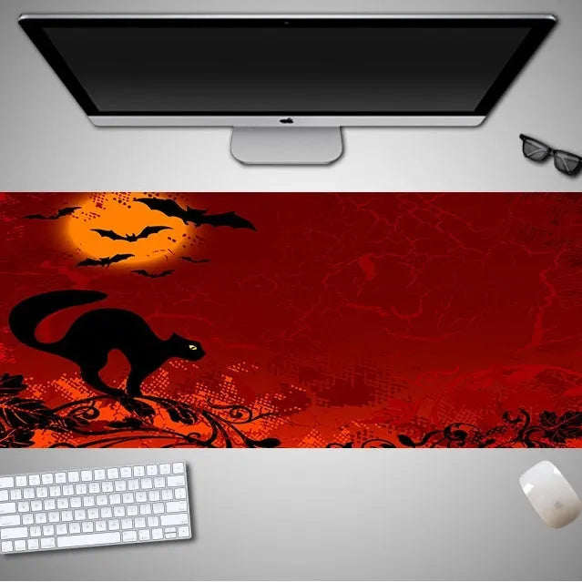 Oversized Halloween-themed gaming mouse pad on a desk, showing anti-slip base and graphic design.