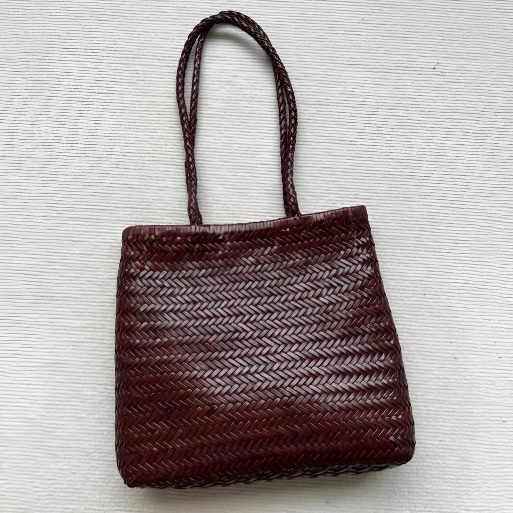 Brown handmade vintage woven leather tote bag with three-dimensional outer pockets.