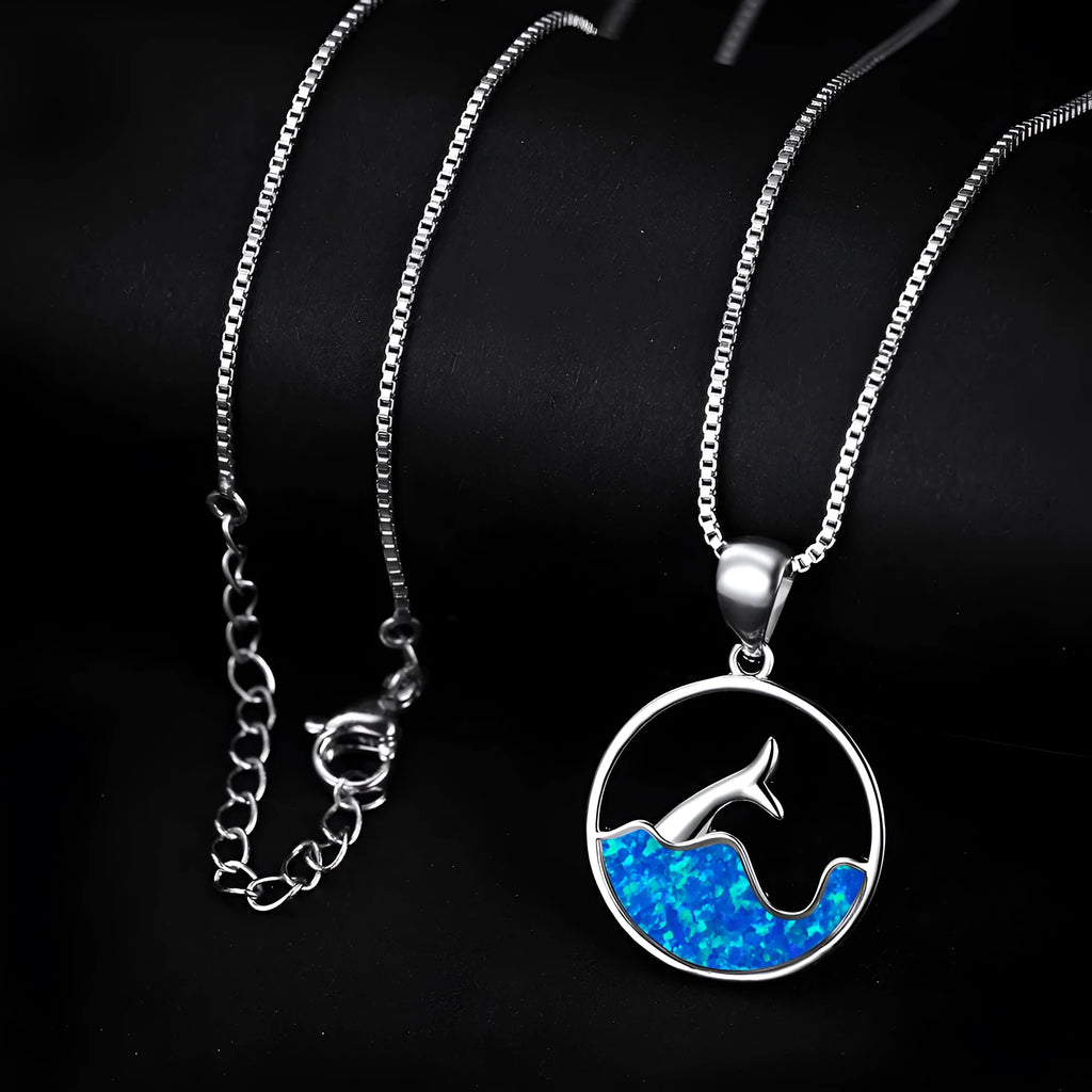 White gold geometric sea fishtail pendant necklace with a round blue opal stone on a chain.