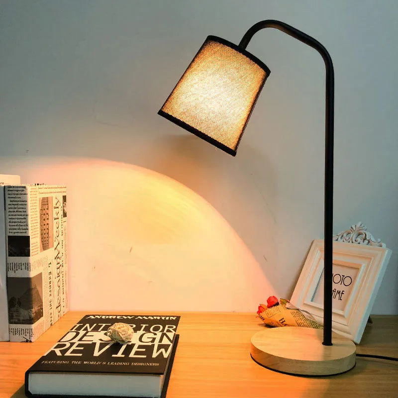A modern LED table lamp with a push button dimmer switch on its base.