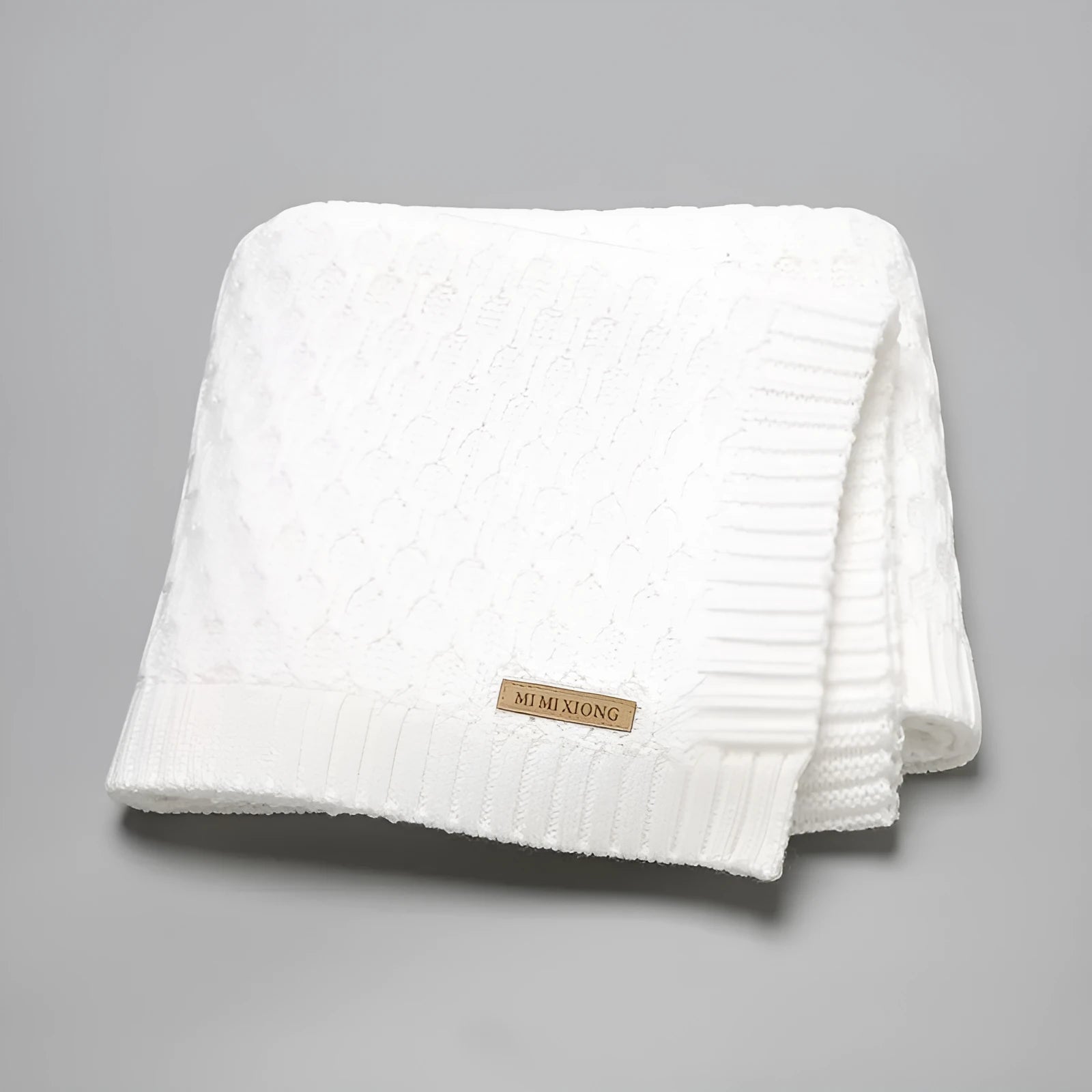 Solid colour infant hug blanket with three-dimensional lines, shown in one of five colour options.