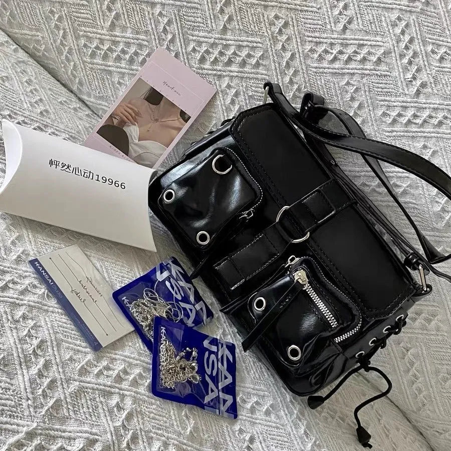 Black women's baguette style messenger bag with adjustable shoulder strap shown from front.