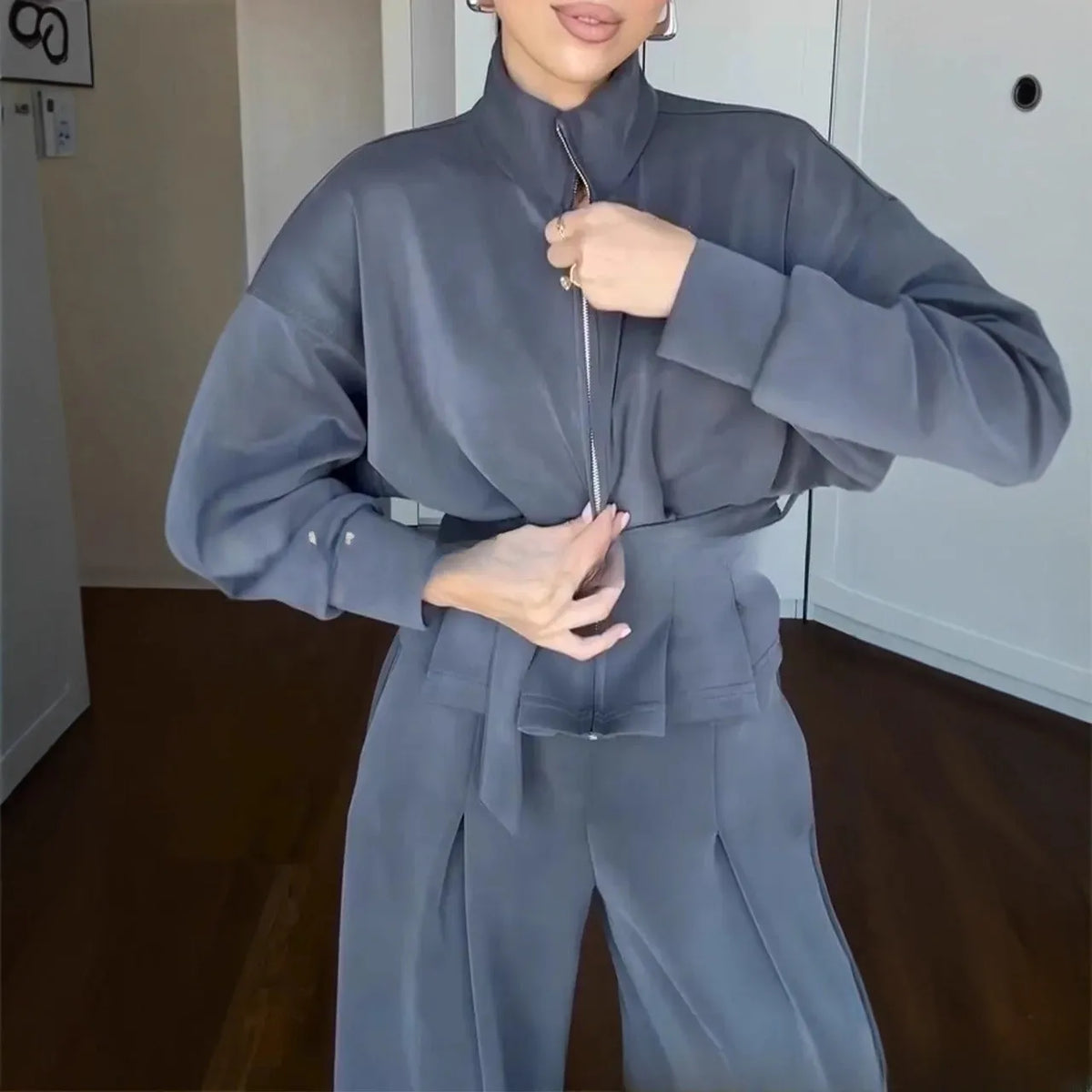 Women's polyester two-piece suit set with stand collar zip jacket and trousers, belt detail, in white dark brown or navy blue.