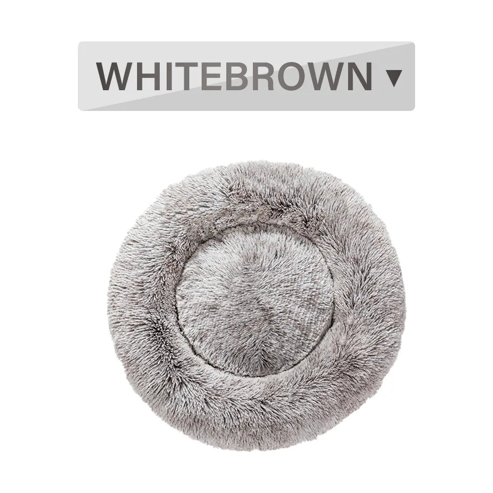 Fluffy donut-shaped dog bed in light grey plush material, showing raised rim and central cushion.